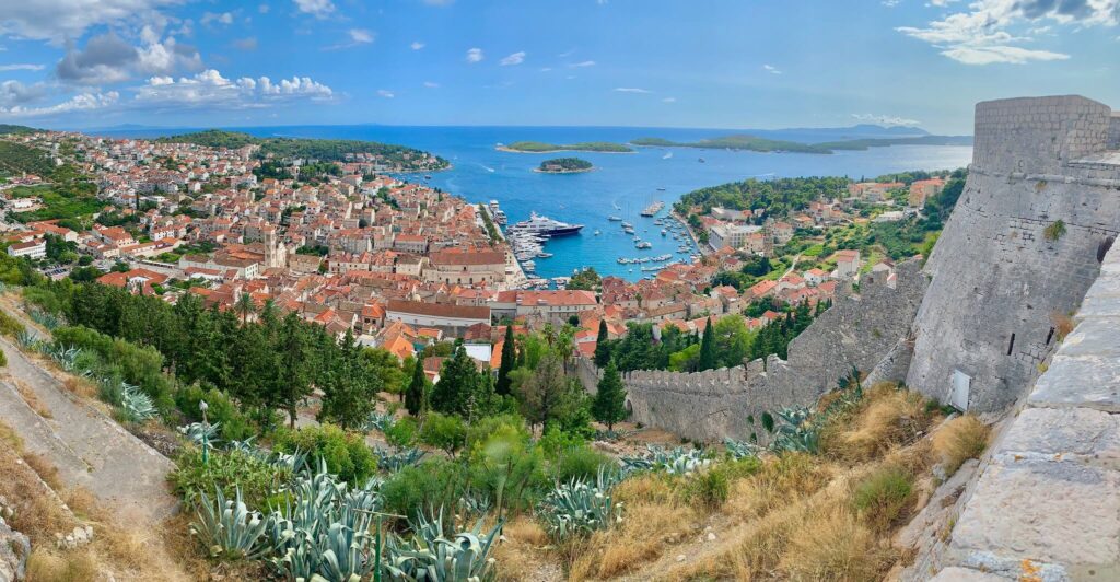Panoramic view of Hvar Town, Croatia, from Spanjola Fortress showing red rooftops, boats in the harbor, and Pakleni Islands in the background