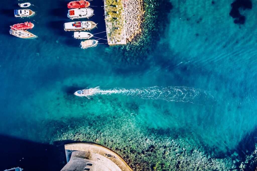 An image of the blue lagoon, we can see the coast and some boats sailing the beautiful Croatian sea.